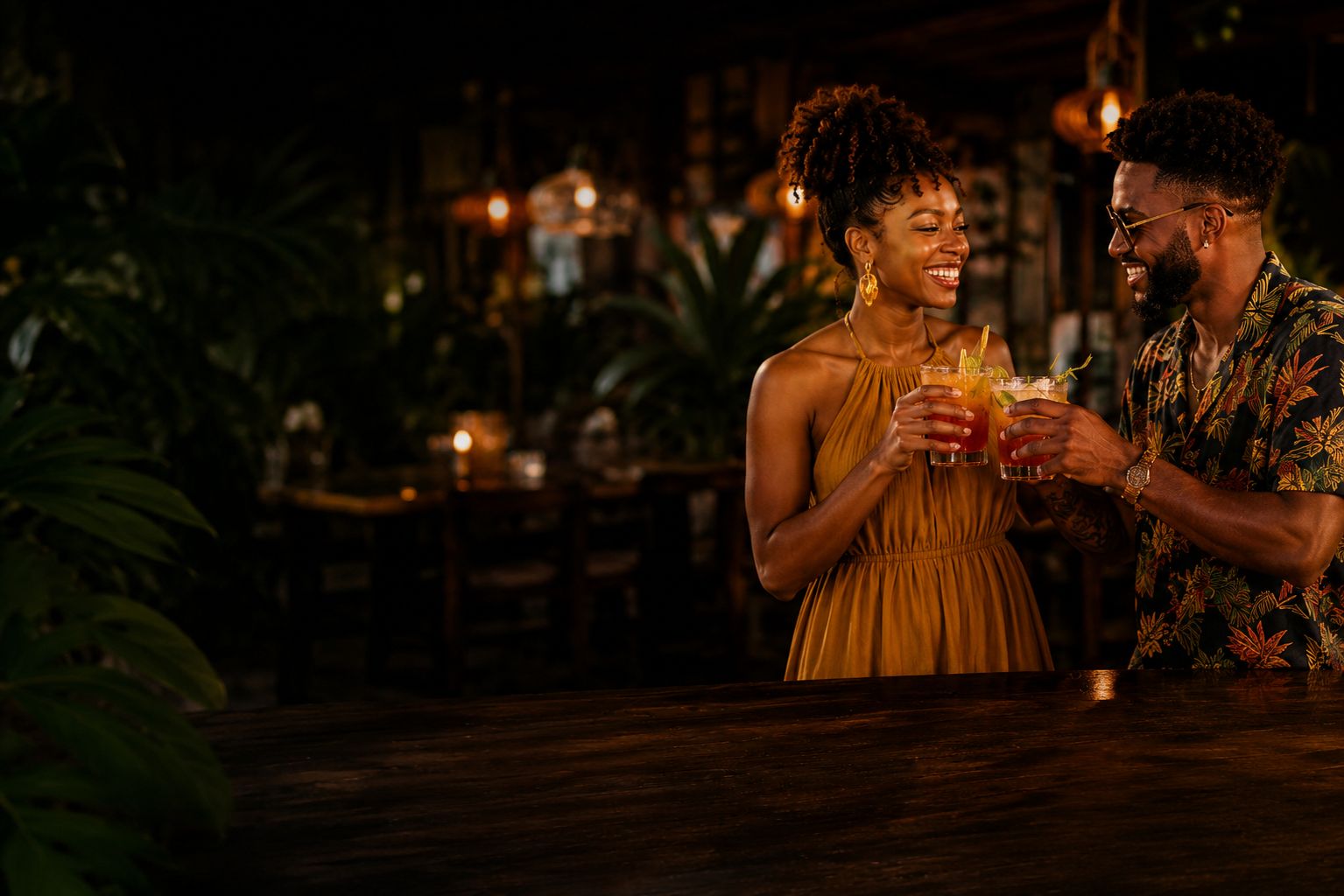 A smiling couple raising tropical cocktails inside Jamaiquita