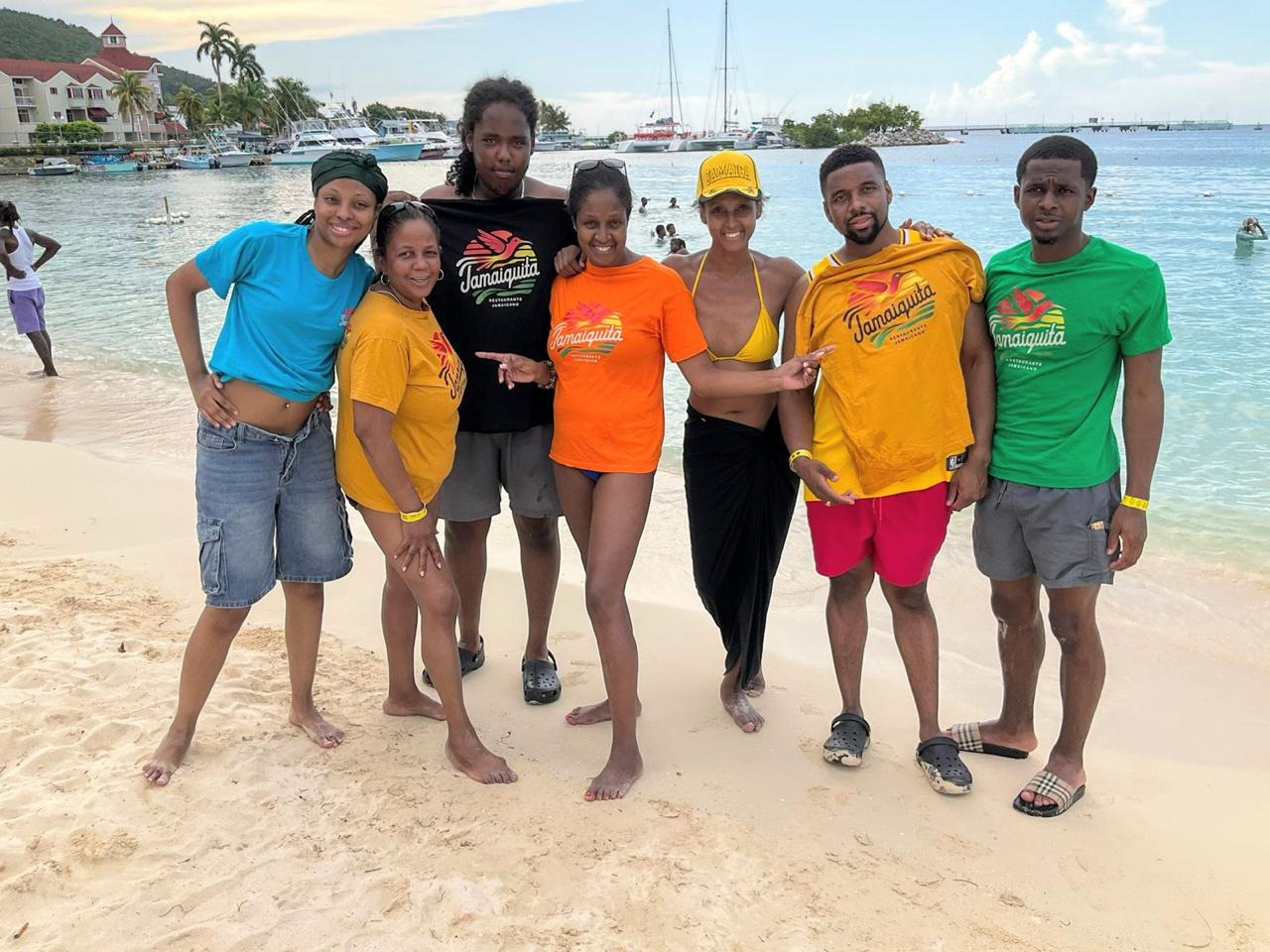 Jamaiquita family group wearing brand shirts on a Jamaican beach